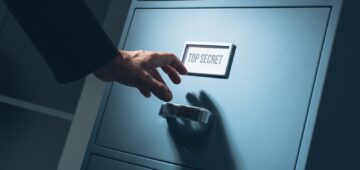 Office worker searching top secret confidential information in the office late at night, data theft and security concept